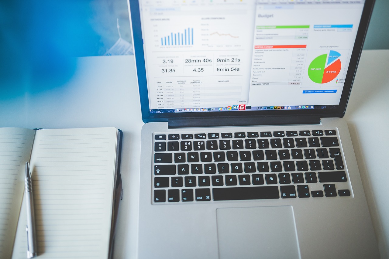 Business charts displayed beside a laptop